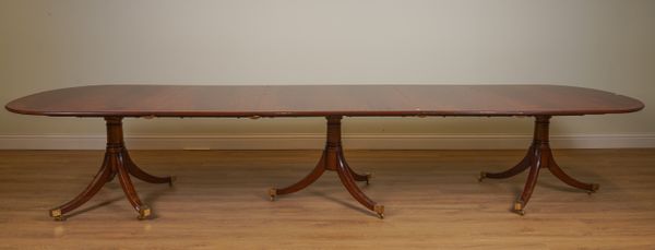 A REGENCY STYLE CROSSBANDED MAHOGANY TRIPLE PEDESTAL EXTENDING D-END DINING TABLE