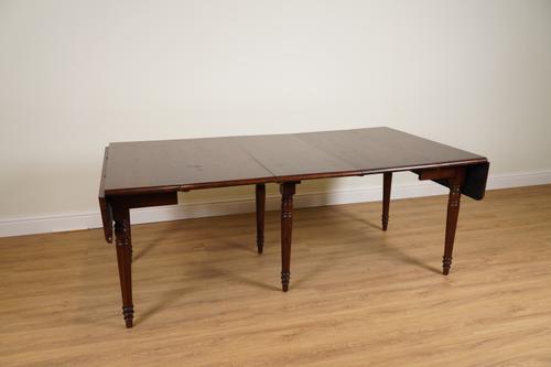 OKA; A WALNUT CONCERTINA ACTION EXTENDING DINING TABLE