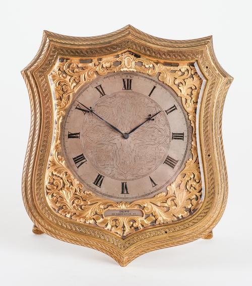 A GOOD VICTORIAN GILT-BRASS AND ENGRAVED SHIELD-SHAPED STRUT TIMEPIECE