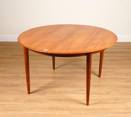 MID-20TH CENTURY DESIGN; A TEAK CIRCULAR EXTENDING DINING TABLE