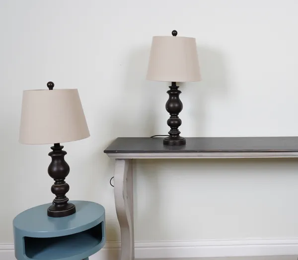 LIGHTING, A PAIR OF FAUX WOODEN TABLE LAMPS WITH TAPERING COTTON SHADES (2)