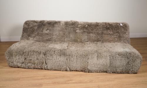 A LARGE TAUPE SHEEPSKIN UPHOLSTERED SOFA