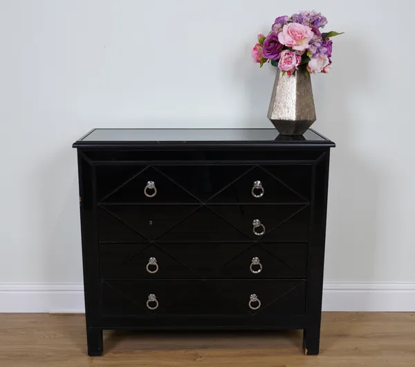 A BLACK MIRRORED CHEST OF DRAWERS