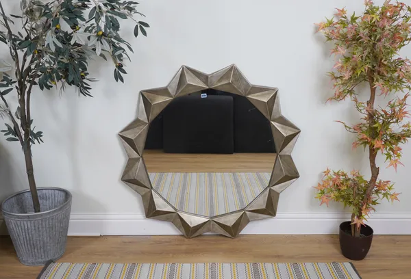 A CIRCULAR SILVERED WALL MIRROR OF STAR FORM