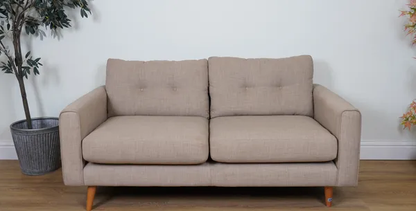 A BEIGE UPHOLSTERED TWO SEATER SOFA