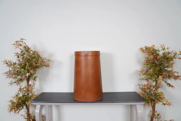 A BROWN LEATHER LAUNDRY BASKET