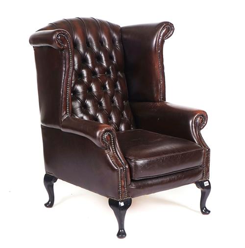 A GEORGE II STYLE BROWN LEATHER UPHOLSTERED WINGBACK ARMCHAIR