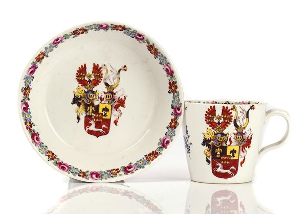 A NYMPHENBURG HAUSMALER ARMORIAL COFFEE CUP AND SAUCER