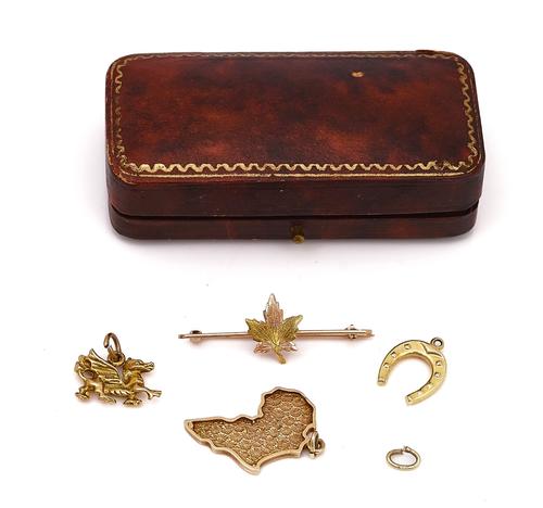 THREE GOLD CHARMS AND A GOLD BROOCH (4)