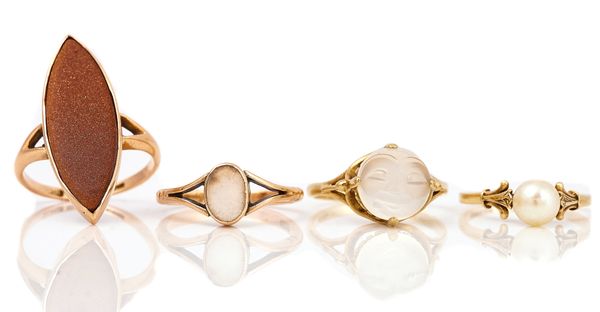 A GOLD AND MOONSTONE RING, DESIGNED AS THE FACE OF THE MOON AND THREE FURTHER RINGS (4)