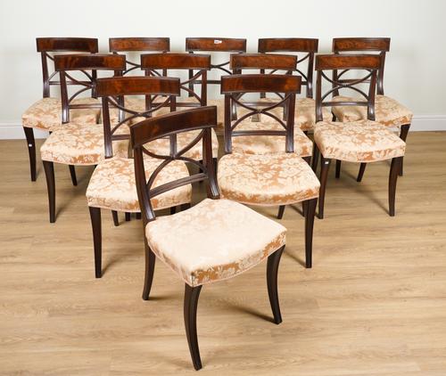 A SET OF TWELVE MAHOGANY FRAMED X-BACK SABRE LEG DINING CHAIRS