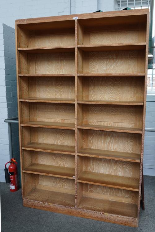 IN THE MANNER OF HEAL’S; A LIMED OAK FLOOR STANDING TWIN SECTION OPEN BOOKCASE
