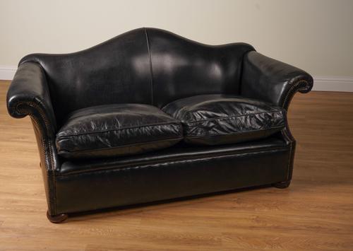 A STUDDED BLACK LEATHER UPHOLSTERED HUMP BACK TWO SEATER SOFA