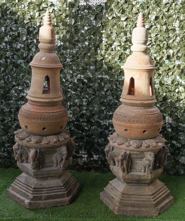 A PAIR OF TERRACOTTA LANTERNS WITH TURNED FINIALS AND OPPOSING ELEPHANT BASES (2)