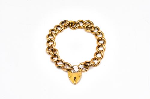 AN ANTIQUE GOLD CURB LINK BRACELET WITH A GOLD HEART SHAPED PADLOCK CLASP