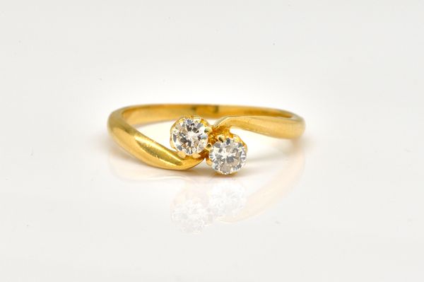 AN 18CT GOLD DIAMOND TWO STONE CROSSOVER RING