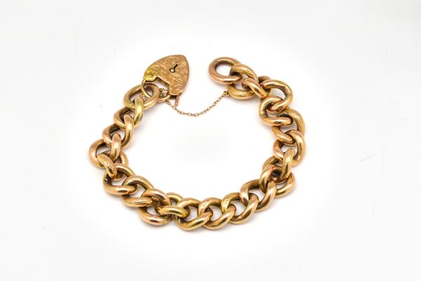 A GOLD CURB LINK BRACELET WITH A HEART SHAPED PADLOCK CLASP