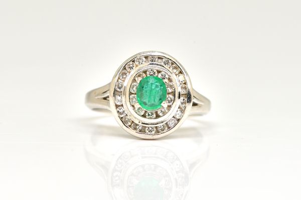 AN EMERALD AND DIAMOND CLUSTER RING