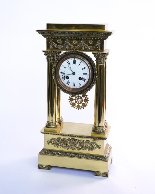 A FRENCH EMPIRE STYLE POLISHED BRASS PORTICO CLOCK