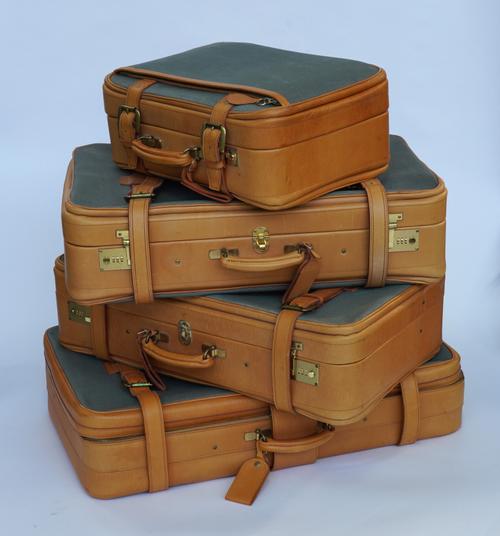 A SET OF FOUR GRADUATED SWAINE ADELEY LEATHER AND CANVAS SUITCASES (4)