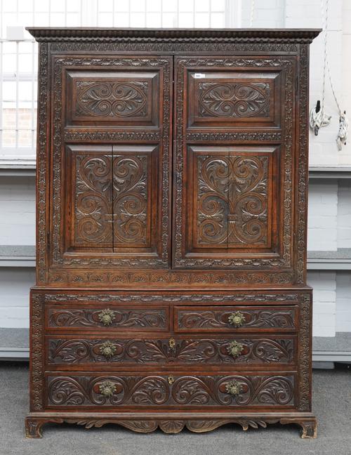 AN EARLY 19TH CENTURY CARVED OAK LINEN PRESS