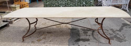 A LARGE STONE TOPPED ROUNDED RECTANGULAR TABLE