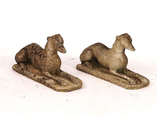 A PAIR OF RECONSTITUTED STONE FIGURES OF RECUMBENT GREYHOUNDS (2)