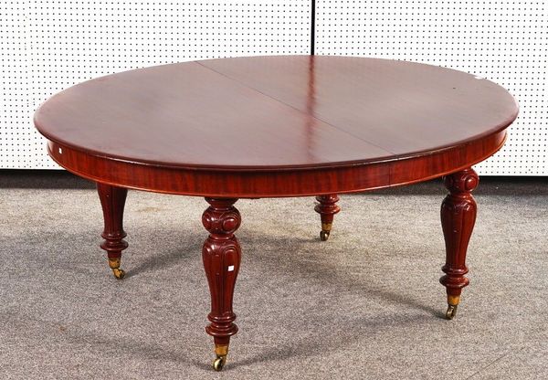 A 19TH CENTURY MAHOGANY OVAL EXTENDING DINING TABLE