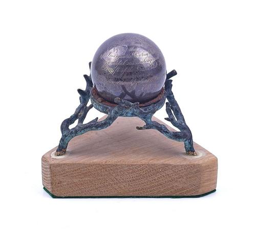 A SILVER PRESENTATION BALL WITH A STAND