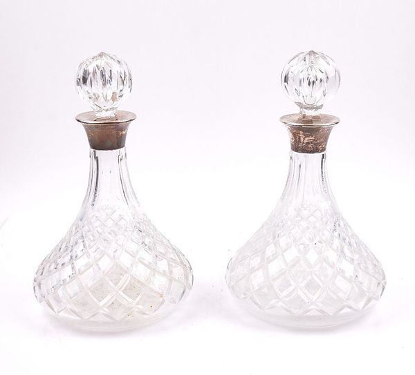 A PAIR OF SILVER MOUNTED FACETED GLASS DECANTERS AND STOPPERS (2)