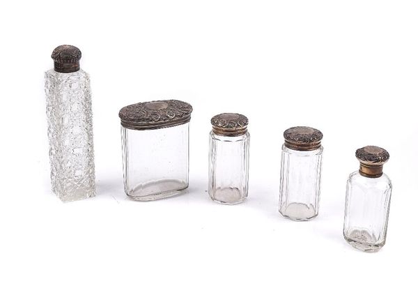 A SILVER TOPPED VICTORIAN GLASS SCENT BOTTLE AND FOUR SILVER TOPPED GLASS TOILET BOTTLES AND JARS (5)