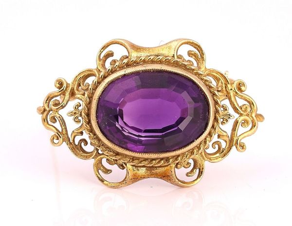 A GOLD AND AMETHYST SINGLE STONE BROOCH