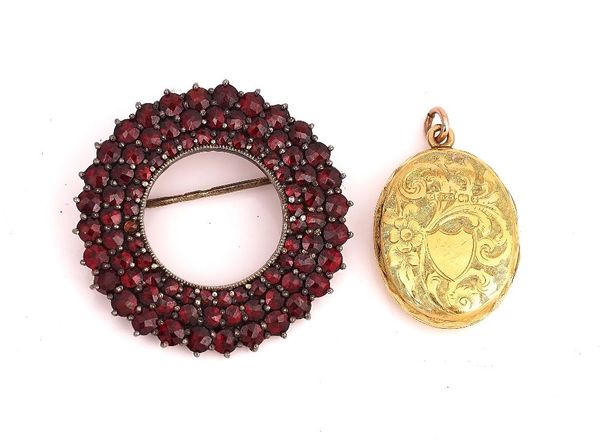 A VICTORIAN 15CT GOLD OVAL PENDANT LOCKET AND A GARNET BROOCH (2)