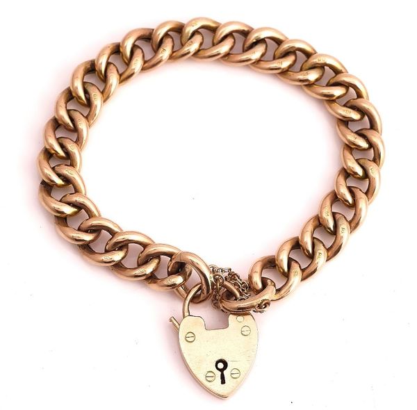 A GOLD CURB LINK BRACELET WITH A HEART SHAPED PADLOCK CLASP