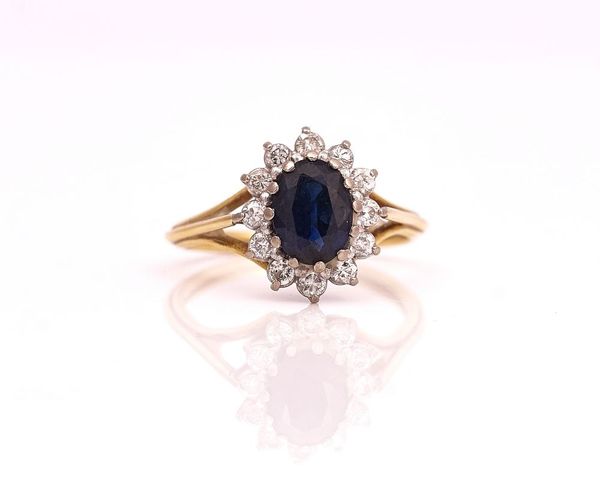 A GOLD, SAPPHIRE AND DIAMOND OVAL CLUSTER RING