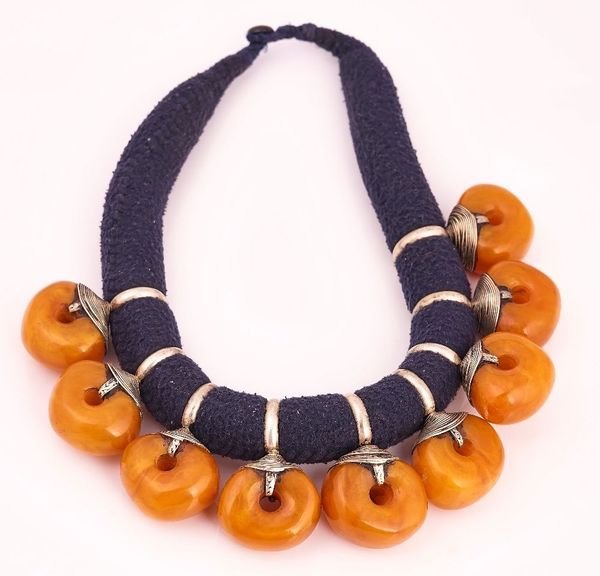 WITHDRAWN A NECKLACE INCORPORATING NINE LARGE CIRCULAR AMBER BEADS