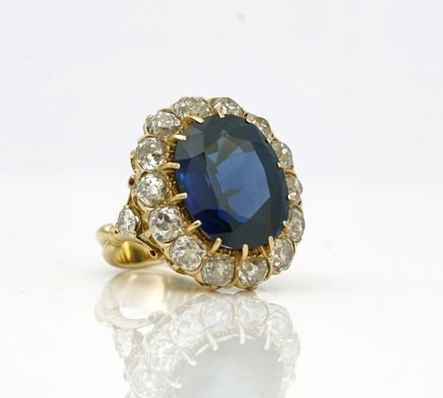 A GOLD, SAPPHIRE AND DIAMOND OVAL CLUSTER RING