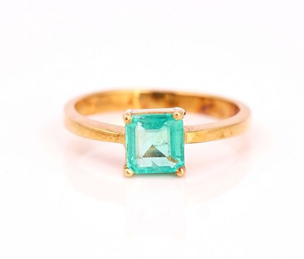 A GOLD RING CLAW SET WITH A CUT CORNERED RECTANGULAR STEP CUT EMERALD