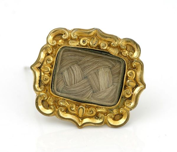 A MID-VICTORIAN GILT METAL MOURNING BROOCH