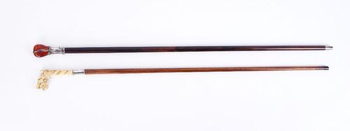 AN ART NOUVEAU SILVER MOUNTED AMBER WALKING CANE AND ANOTHER (2)