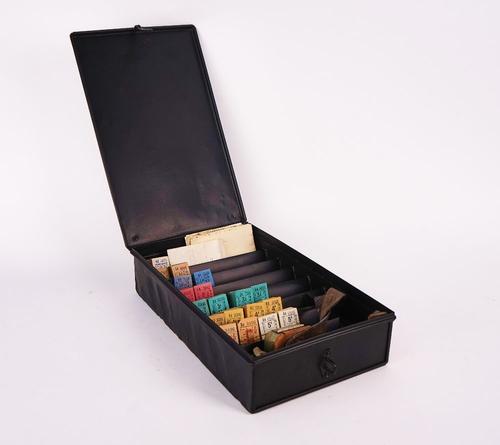 A WILLIAMSON TICKET PRINTER AND A QUANTITY OF BLANK BUS TICKETS IN A BLACK PAINTED METAL TICKET BOX