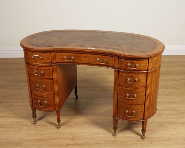 MAPLE AND CO.; A SATINWOOD BANDED MAHOGANY KIDNEY SHAPED NINE DRAWER WRITING DESK