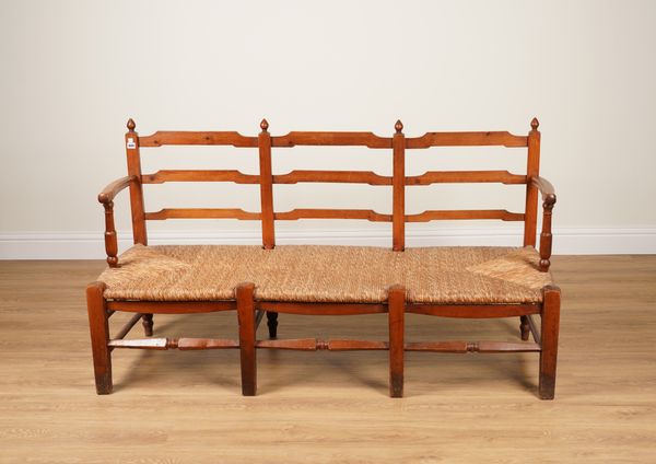 A 19TH CENTURY PINE FRAMED TRIPLE LADDER CHAIR BACK RUSH SEAT SETTLE