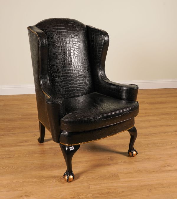 GREENGATE; A FAUX BLACK CROCODILE SKIN UPHOLSTERED WINGBACK ARMCHAIR ON PARCEL GILT BALL AND CLAW FEET