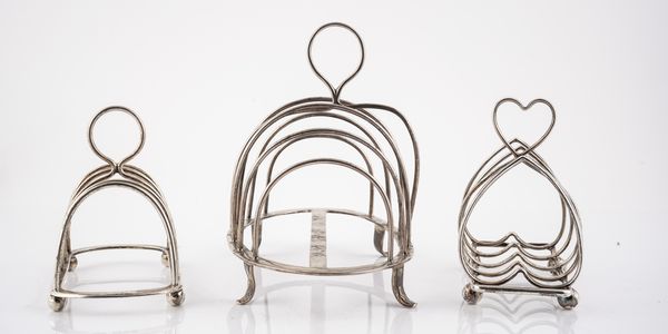 A GEORGE III SILVER SEVEN BAR TOASTRACK AND TWO FURTHER SILVER TOASTRACKS (3)