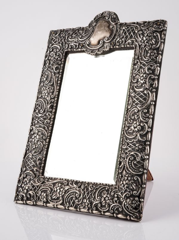 A VICTORIAN SILVER MOUNTED SHAPED RECTANGULAR STRUT BACKED MIRROR