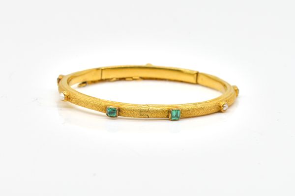 A GOLD, GREEN TOURMALINE AND HALF PEARL SET OVAL HINGED BANGLE