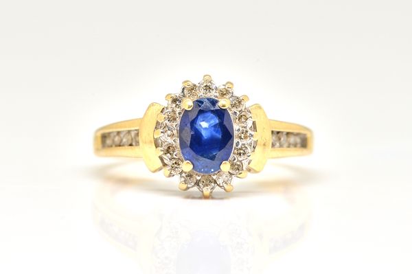 A GOLD, SAPPHIRE AND DIAMOND CLUSTER RING