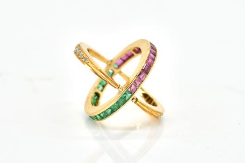 A GOLD, EMERALD, RUBY AND DIAMOND SWING OVER AND UNDER ETERNITY RING