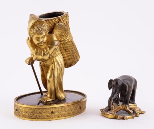 A CHARLES X PALAIS ROYAL GILT-METAL SPILL HOLDER MODELLED AS A WINGED CHERUB BEARING A SHEAF OF WHEAT (2)